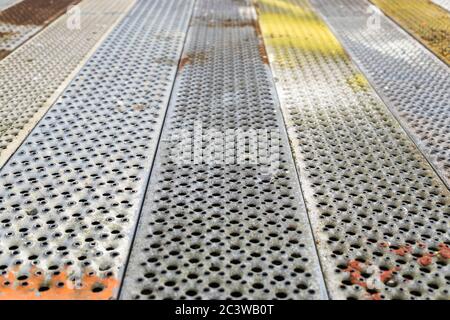 Metal background with perforation of square holes. Gray and colorful steel texture of sand metal sheet Stock Photo
