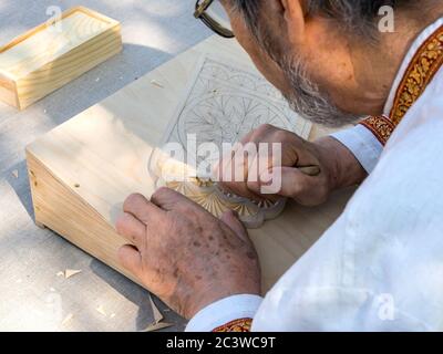 Voronezh, Russia - September 05, 2019: The master makes a carved wooden cutting board