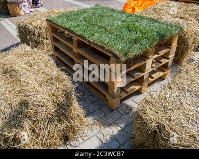 Wooden table with chairs of hay bales on the fair Stock Photo - Alamy