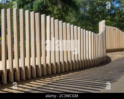 Fence from vertical wooden boards of various heights Stock Photo