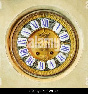 Authentic ancient ornamental golden clock with enamel roman numbers Stock Photo