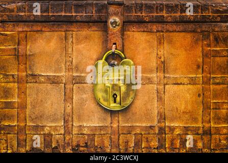 Retro styled image of an ancient locked rusted treasure chest with large brass lock Stock Photo