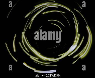 Yellow neon light sparkle swirl isolated on black background Stock Photo