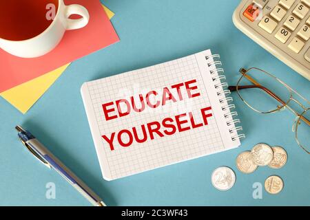 Educate Yourself is written on a notepad, on an office desk with office accessories. Stock Photo