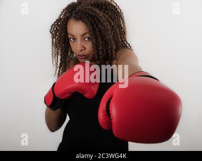 Horizontal portrait of an Afro American woman wearing red boxing gloves Stock Photo
