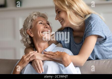 Grown up daughter hugging elderly mother feeling love showing care Stock Photo