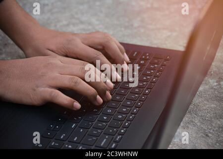 Businessman using laptop with hands typing on a keyboard Stock Photo