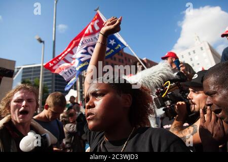 Tulsa, Oklahoma, USA. 20th June, 2020. Sincere Terry, a spokeswoman for Black Lives Matter, holds up a fist to Trump supporters outside of the BOK Center in Tulsa, Oklahama, where the President is holding a rally on June 20, 2020. Credit: Leslie Spurlock/ZUMA Wire/Alamy Live News Stock Photo