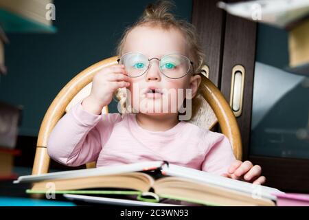 Little girl corrects adult glasses of her mother on her face. Child playing Stock Photo