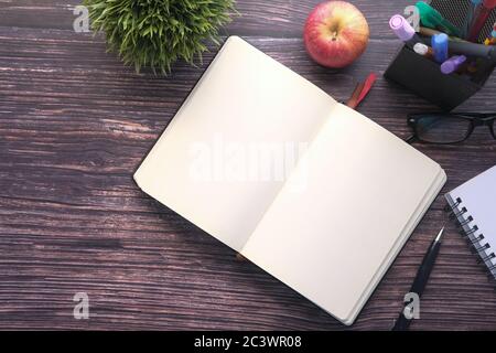 high angle view of open empty books and apple on desk  Stock Photo