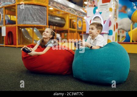 Children plays game console, entertainment center Stock Photo