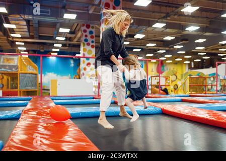 Mother and little girl jumping on a trampoline Stock Photo