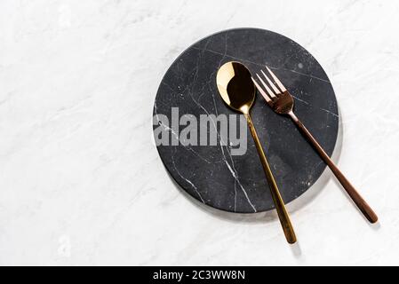 fork and spoon on a black marble tray Stock Photo