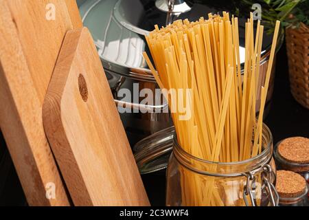 Dry spaghetti on a kitchen counter with cooking utensils Stock Photo