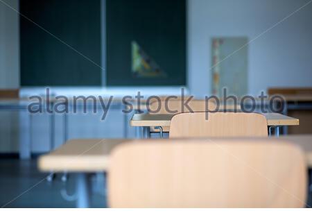 School desks and chairs in an empty classroom in Germany as the corona crisis continues to hit education hard. Stock Photo