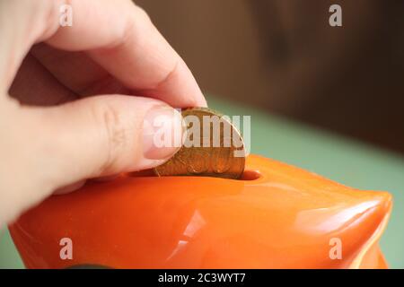 Hand puts euro coin in saving moneybox. Money saving and investment financial concept Stock Photo