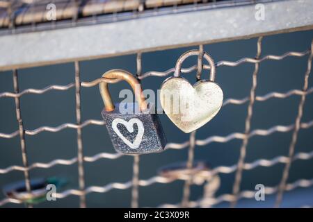 Two old rusty padlocks with heart on the bridge Stock Photo