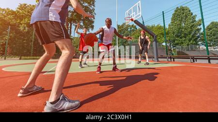 Panoramic view of diverse basketball team during game match at court, copy space Stock Photo