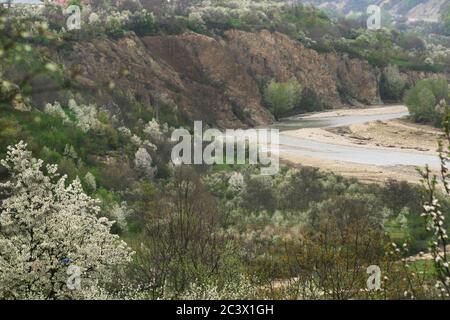 Putna River Valley, Vrancea County, Romania.Spring landscape with blossoming fruit trees on the cliffs and in the valley. Stock Photo