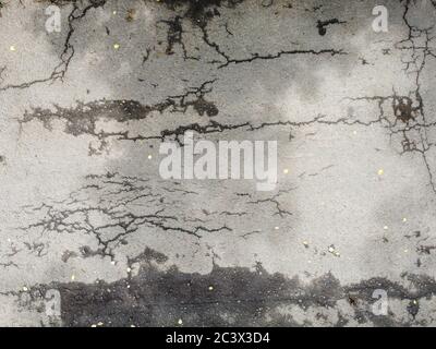 Cracks on the asphalt road surface, texture of the damaged road surface. Stock Photo