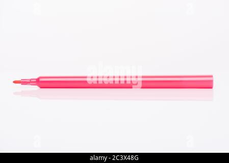 Side profile view close-up photo of pink marker with cap off isolated on white background Stock Photo
