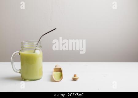 Matcha latte with coconut milk in jar glass on white background Stock Photo