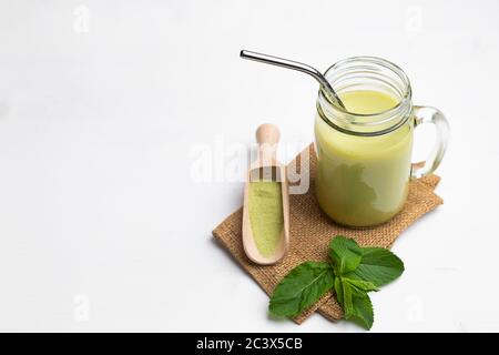 Matcha latte with coconut milk in jar glass on white background Stock Photo