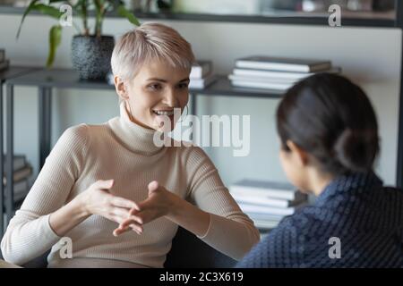 Confident businesswoman talk with client during formal meeting in office Stock Photo