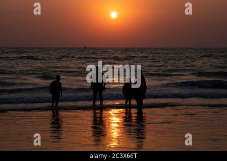 Silhouette of family on the beach at sunset at Majorda beach in Goa, India. Stock Photo
