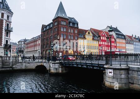 Copenhagen / Denmark - November 2019: Typical forecast day at Nyhavn harbor in Copenhagen. People walking, cars and bicycles moving around. Colorful. Stock Photo