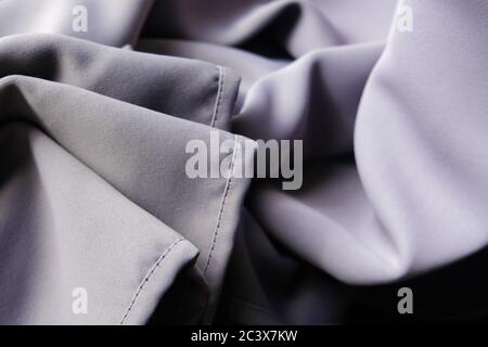 Rumpled creased wrinkled material. Soft violet grey silk fabric. Smooth textile backdrop. Folded edges and shadows in wrinkles. Interior design Stock Photo