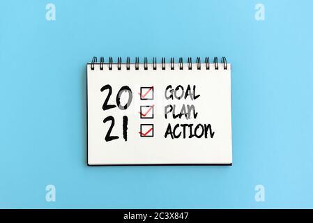 2021 goal, plan, action checklist text text on note pad blue background Stock Photo