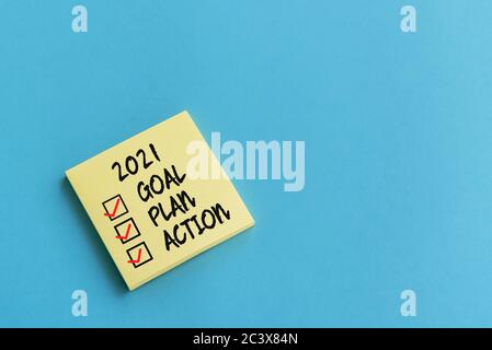 2021 goal, plan, action checklist text on adhesive note blue background Stock Photo