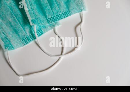 Two standard blue face medical masks on a white table. Self protection from virus, bacteria, sickness, corona or flu. Prevention methods Stock Photo