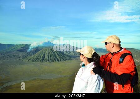 Couple stay on the top near volcano Bromo in Indonesia Stock Photo