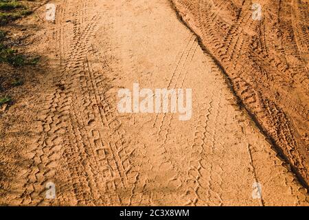 Tire tracks left after a jeep safari on a muddy road. A brown texture with a dirty sandy surface from the Udawalawe National Park, Sri Lanka. Stock Photo