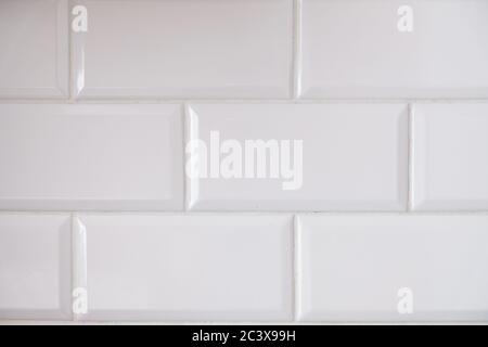 Close up view of white tiled kitchen wall. Typical interior design idea. Clean big rectangular tiles in modern architecture. Geometric pattern Stock Photo