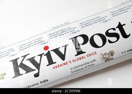 Lviv / Ukraine - March 2020: Close up view of the front page of folded Ukrainian newspaper Kyiv Post on a white desk. Reading and working from home Stock Photo