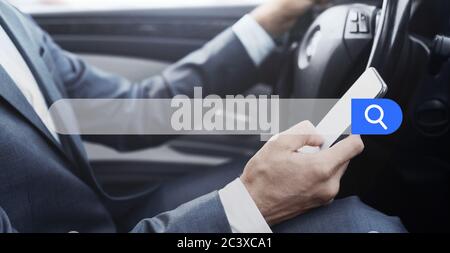 Businessman Using Smartphone While Driving Car With Empty Search Bar On Foreground Stock Photo