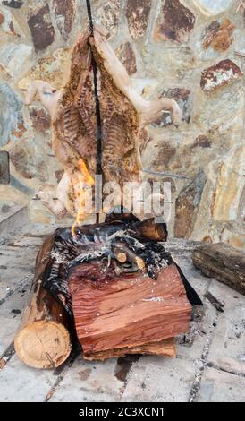 Suckling pig cooking over an open fire/BBQ outside restaurant in Spain. Stock Photo