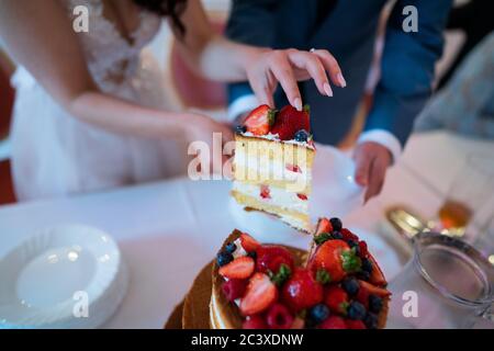 Newlyweds cutting a wedding cake Stock Photo