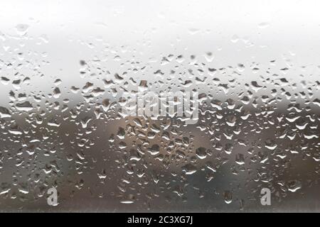 Close-up of water drops on the window glass. Rain drops on glass. Blurry backdrop, background, wallpaper, texture Stock Photo