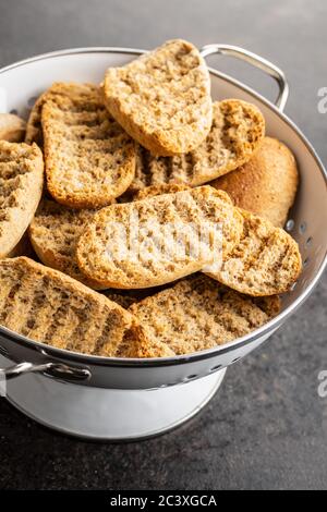 Rusk bread. Dried crispbread in colander. Stock Photo