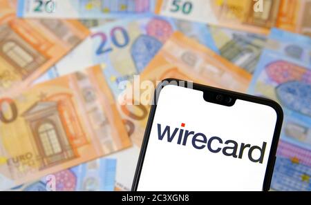 Wirecard logo on smartphone and euro banknotes on the blurred background. Wirecard AG is a universal payments platform. Stock Photo