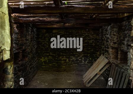 A small room with stone walls. The old cellar. A dark room. Stock Photo