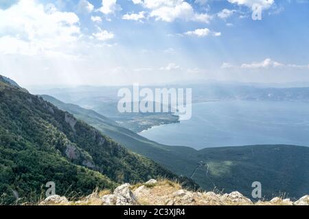 Galichica Mountains. View from above on the Ohrid lake and winding road with mountains in background and blue sky. North Macedonia, Europe. Stock Photo