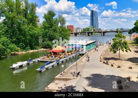 Frankfurt am Main, Germany - June 2020: Swimming restaurant on boat called 'Yachtclub' on Main river in Frankfurt on sunny day with skyscrapers Stock Photo