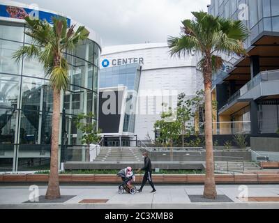 A family wearing masks are walking next to the Chase Arena in San Franciscos Mission Bay neighborhood. Stock Photo