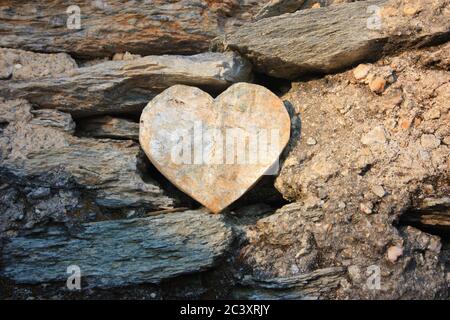 heart shape of rock between stones between dust and soil Stock Photo