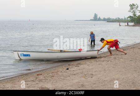 Toronto, Canada. 22nd June, 2020. A lifeguard pushes a lifeboat into Lake Ontario at Cherry Beach in Toronto, Canada, on June 22, 2020. Lifeguards returned to six of Toronto's swimming beaches beginning on Monday. Credit: Zou Zheng/Xinhua/Alamy Live News Stock Photo